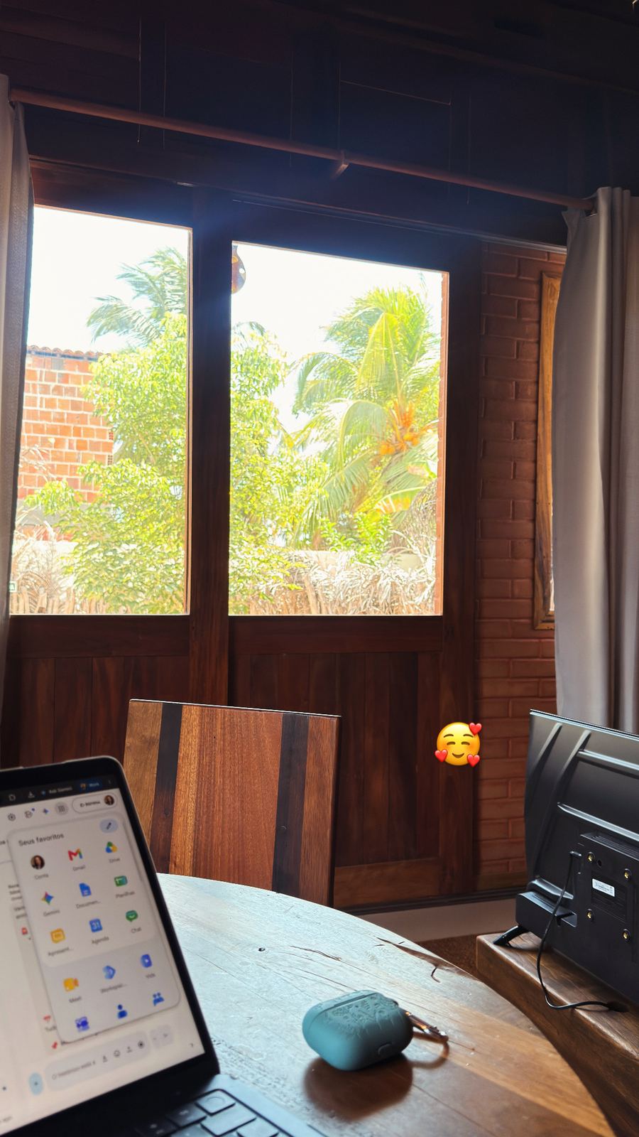 Mesa de trabalho com notebook dentro do Ecoloft, com janelas de madeira abertas para o jardim