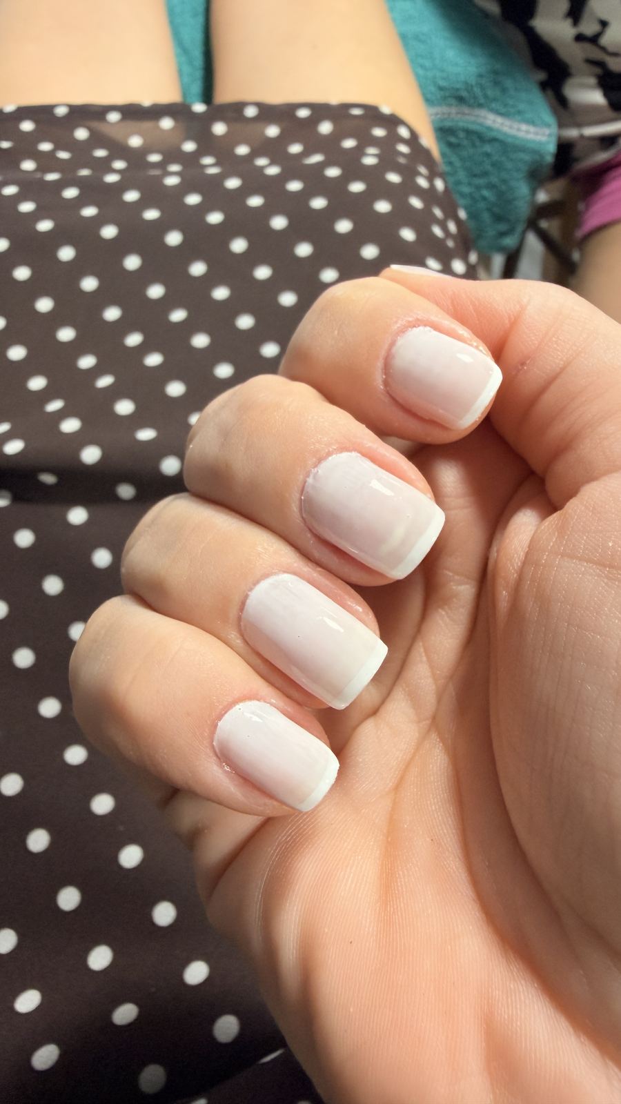 Unhas das mãos pintadas de branco, feitas com a manicure do Preá