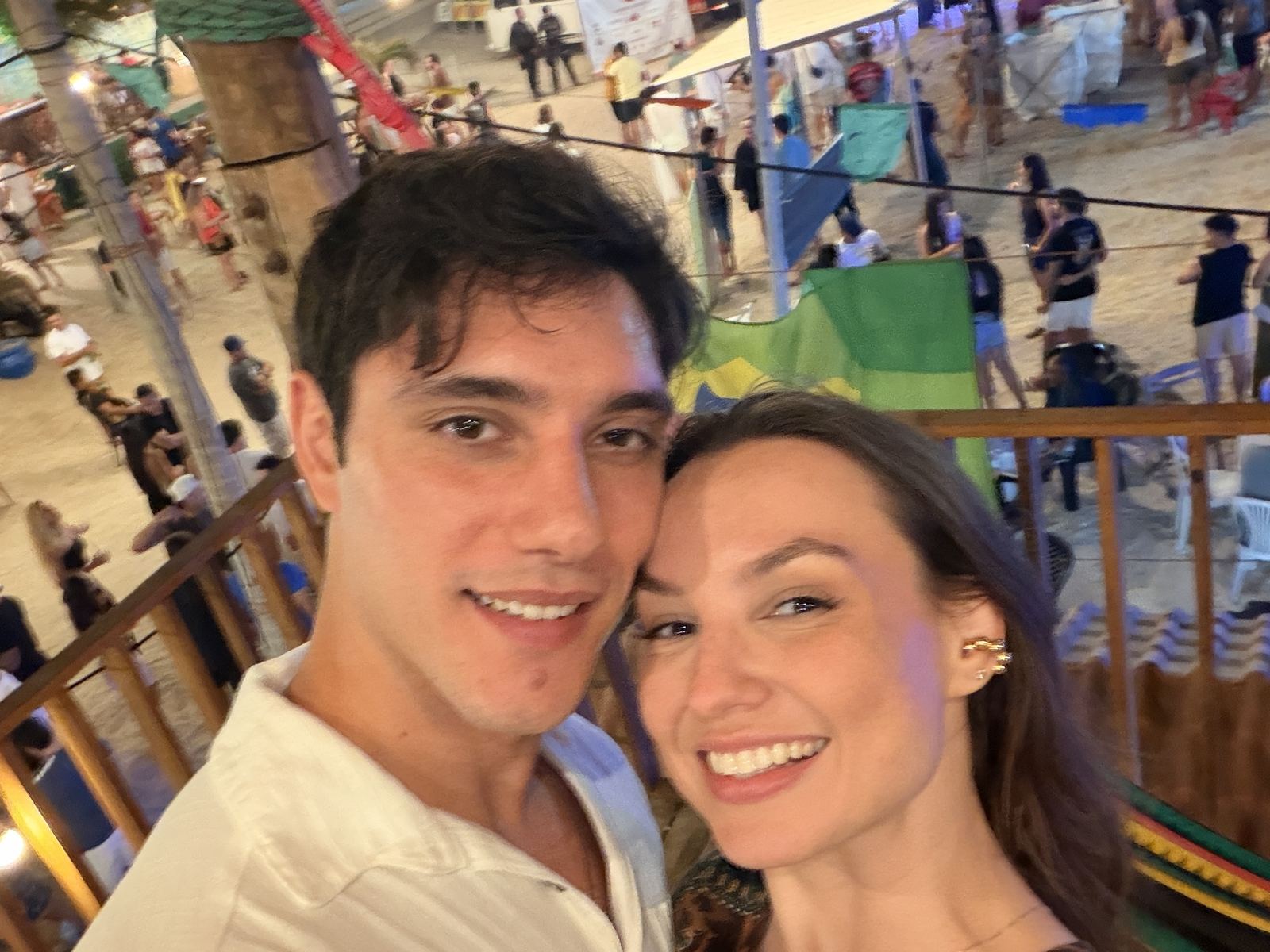 Lidiane Grigoletto à noite na rua da Praia do Preá, com a feirinha iluminada ao fundo
