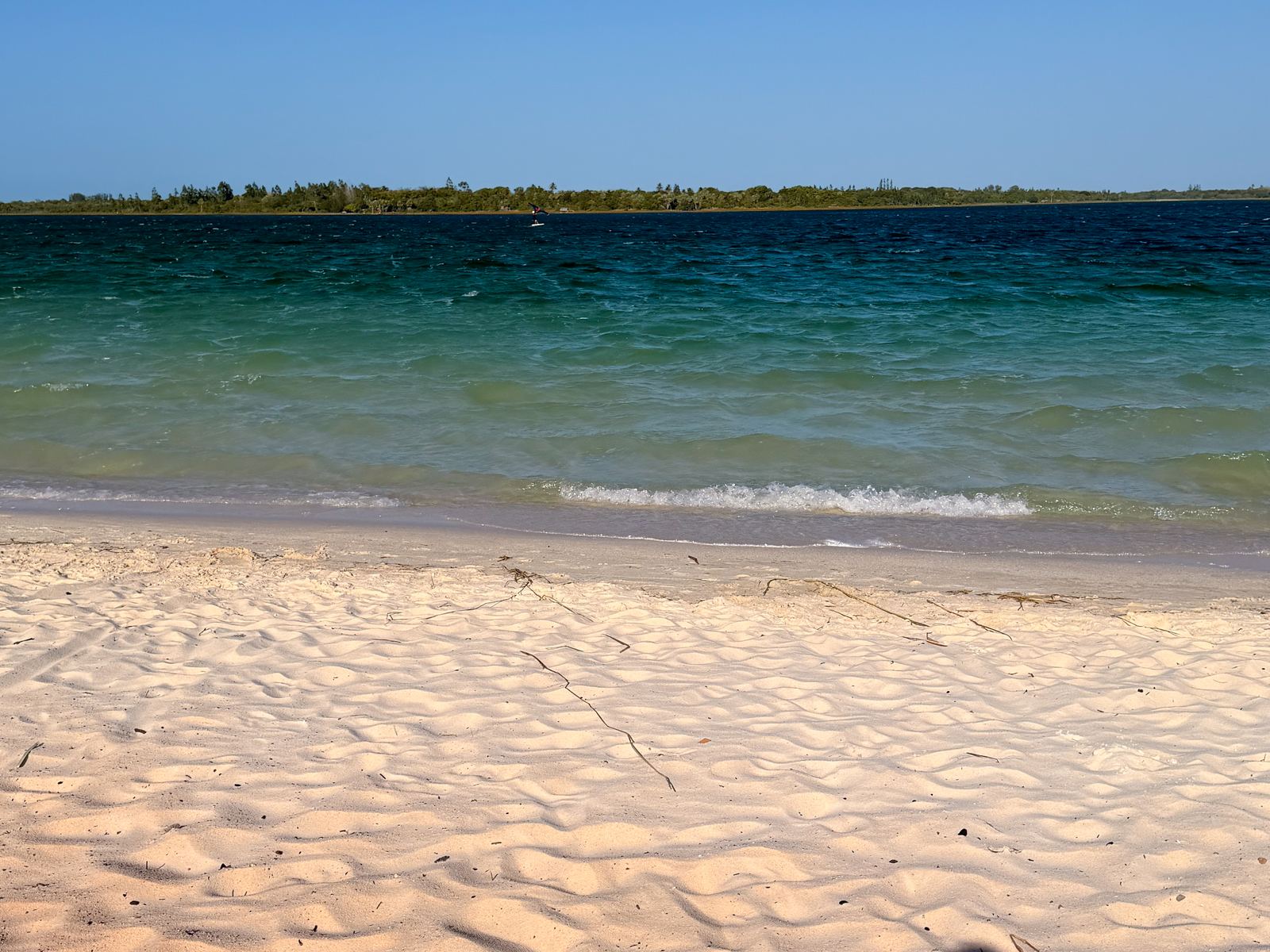 Água verde e azul cristalina da Lagoa do Paraíso, com a faixa de areia branca na frente