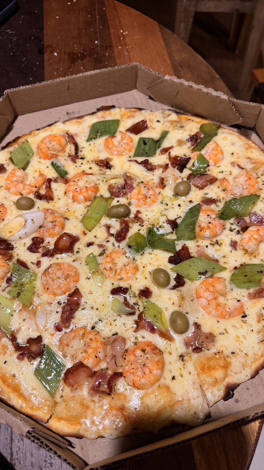 Pizza de camarão com azeitonas e manjericão na caixa, entregue em casa no Preá
