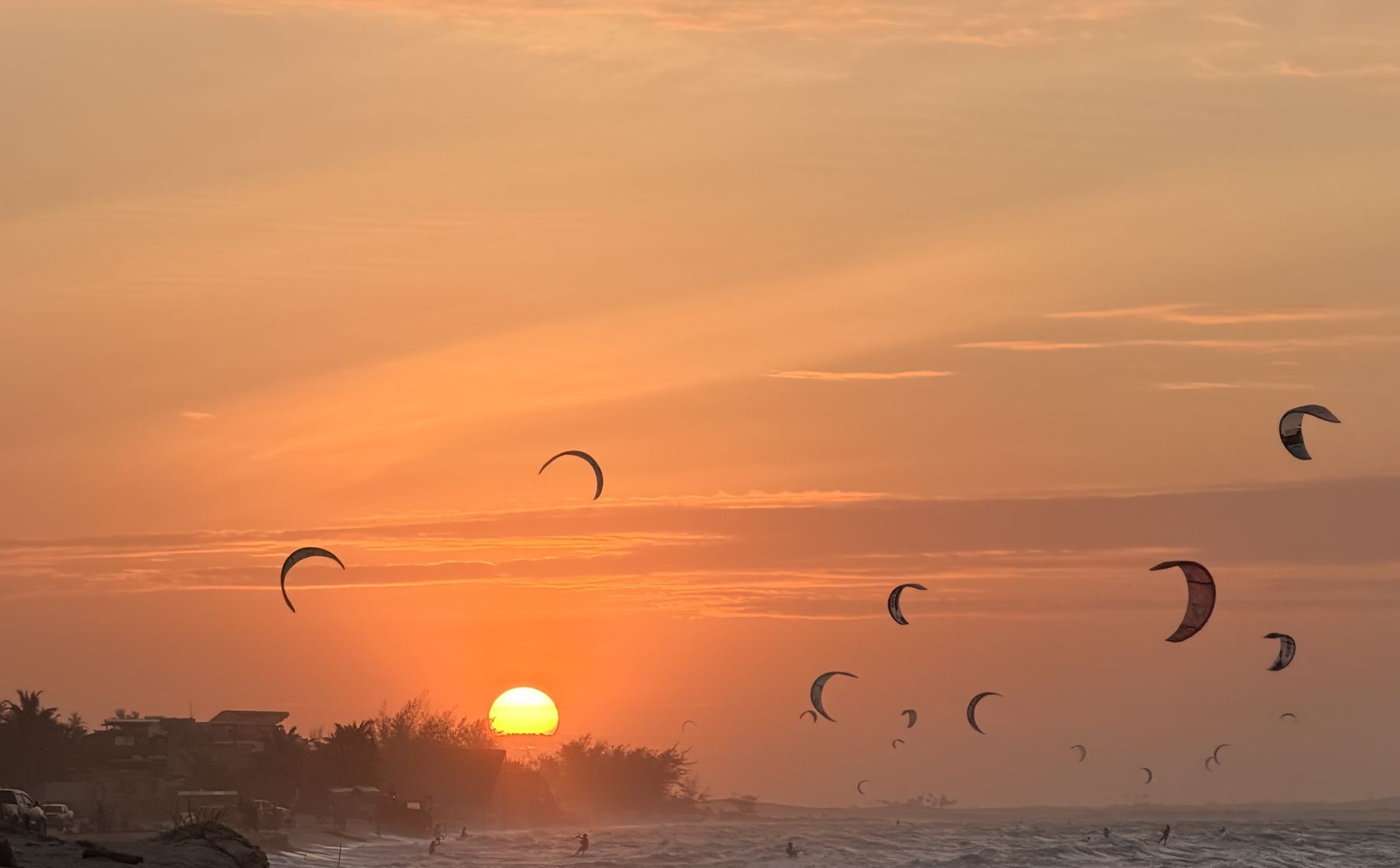 Pôr do sol na Praia do Preá, com dezenas de kites no céu e o sol se pondo atrás dos coqueiros
