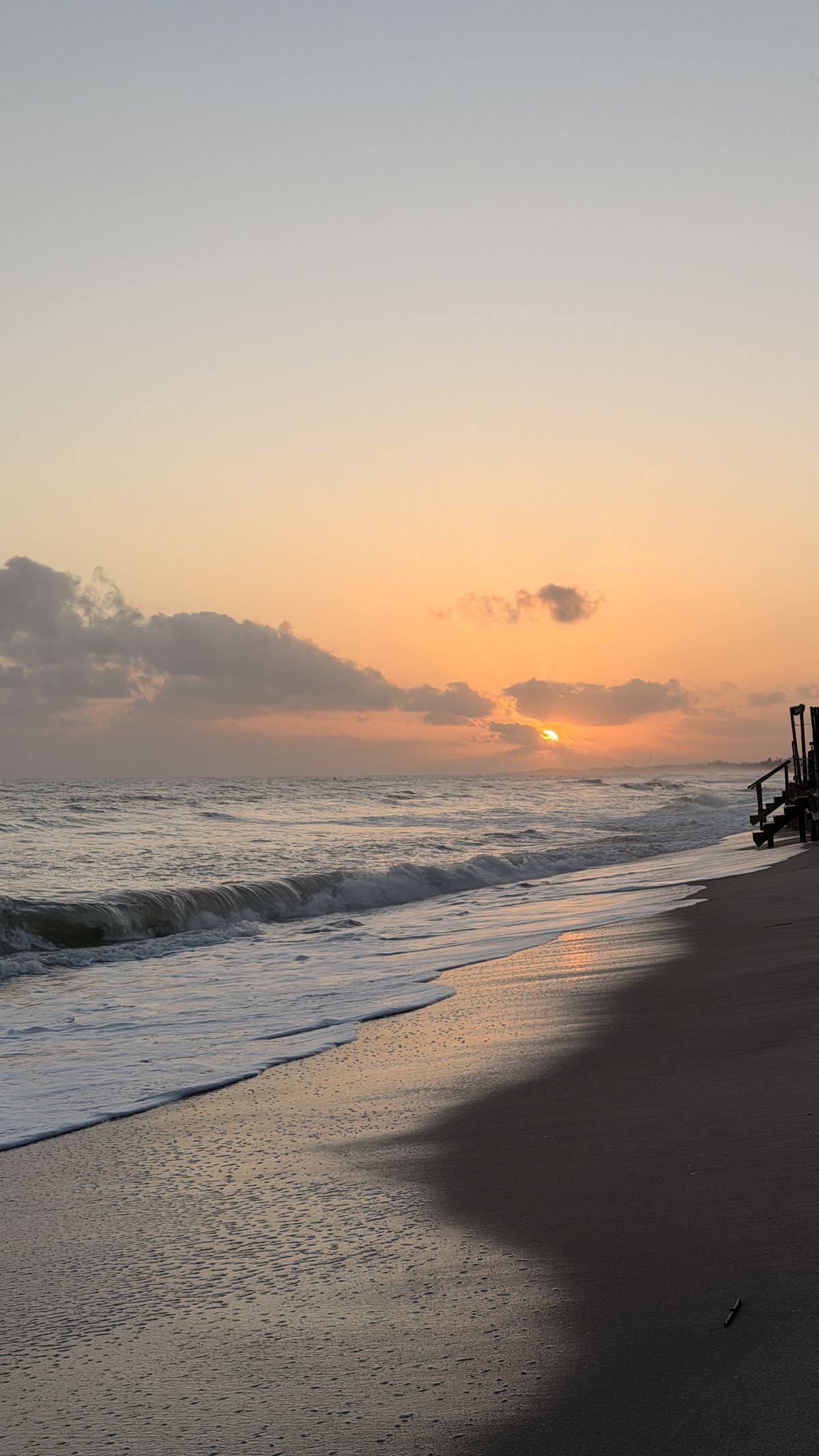 Nascer do sol na Praia do Preá, com a faixa de areia molhada refletindo o céu