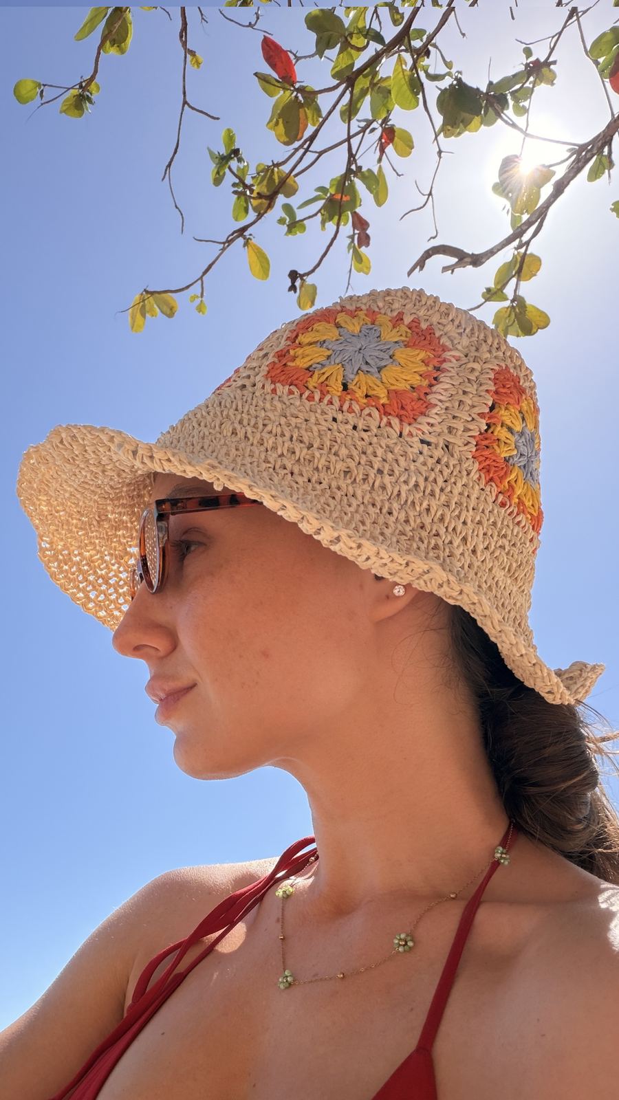 Lidiane Grigoletto na praia usando o chapéu de crochê colorido comprado na loja Flower