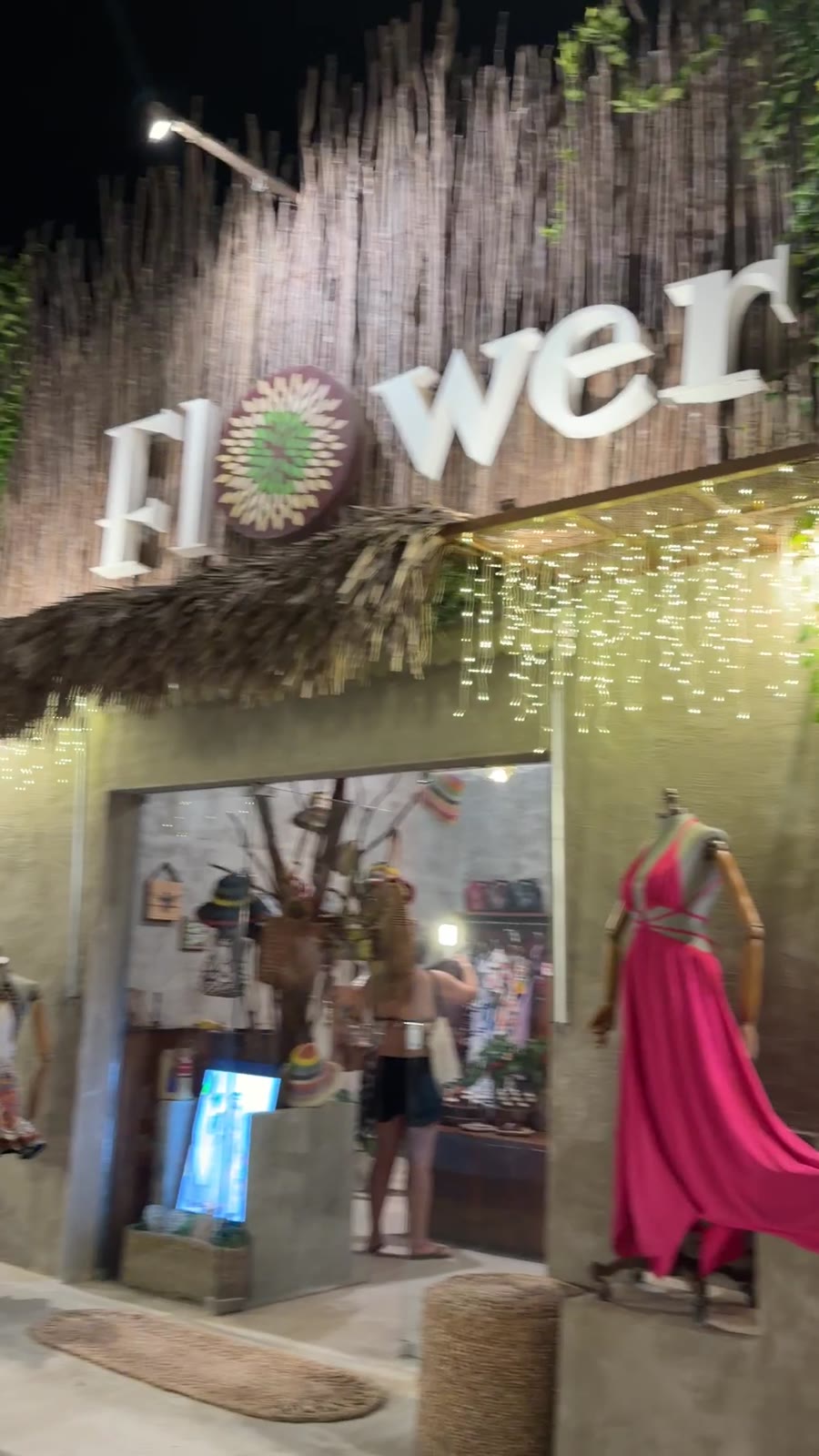 Fachada iluminada da loja Flower, em Jericoacoara, com chapéus e vestidos na vitrine